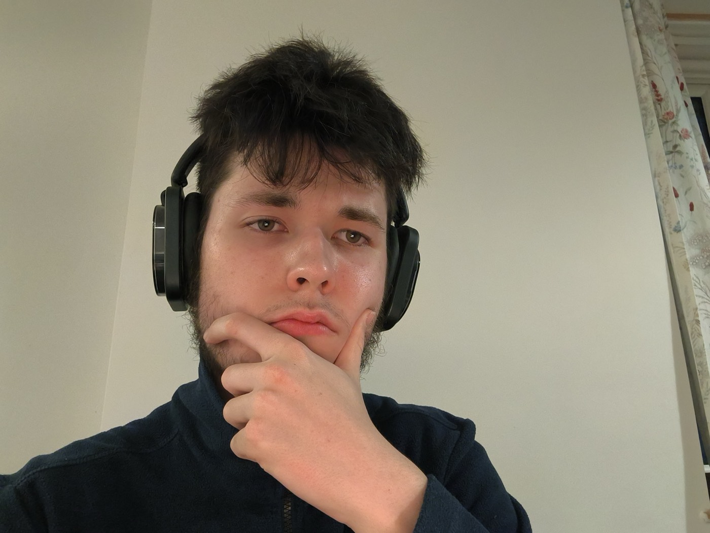 Reuben in headphones, hand on chin